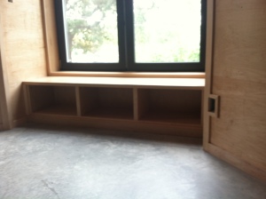 three cabinets under the large bay window seat